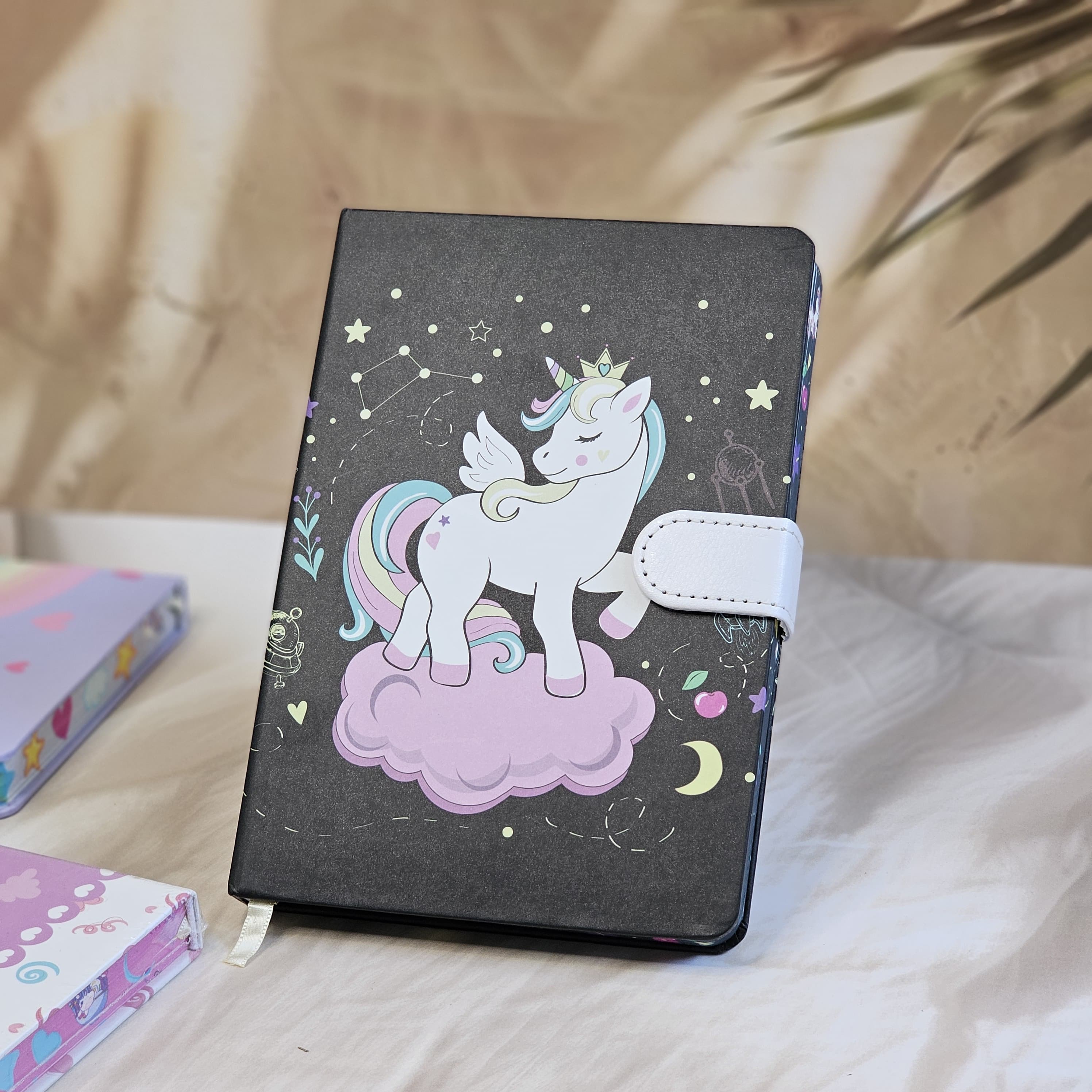 Set of four small unicorn-themed notebook diaries for kids, each with a lock, displayed on a textured surface." www.usmile.toys