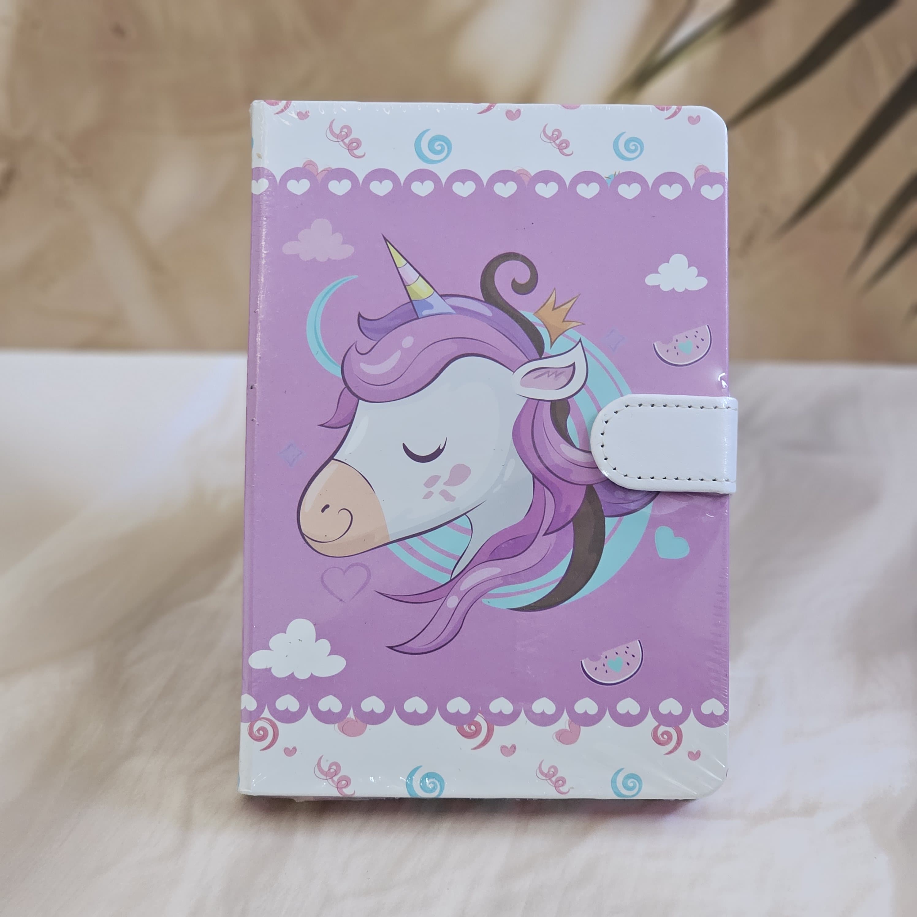 Set of four small unicorn-themed notebook diaries for kids, each with a lock, displayed on a textured surface www.usmile.toys