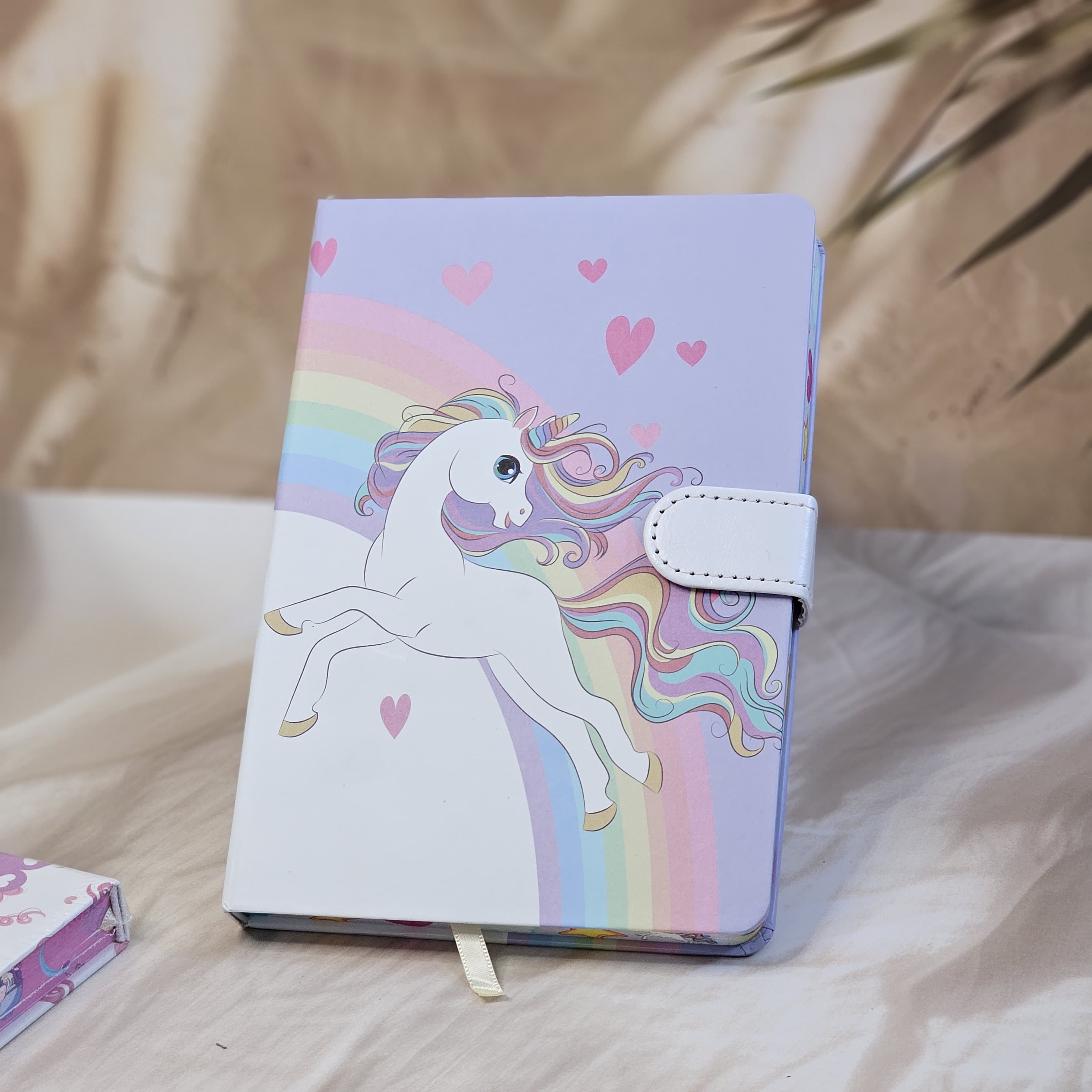 Four colorful pocket-sized diaries with unicorn illustrations, including a light blue diary that reads 'TIME TO BE A UNICORN', each with a clasp lock www.usmile.toys