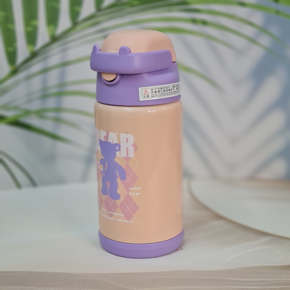 Close-up of two Usmile Toys SS vacuum water bottles, each nestled inside a unique teddy bear-like protective sleeve, showing the pink and purple bottle tops." www.usmile.toys 