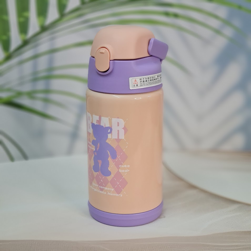 Close-up of two Usmile Toys SS vacuum water bottles, each nestled inside a unique teddy bear-like protective sleeve, showing the pink and purple bottle tops." www.usmile.toys