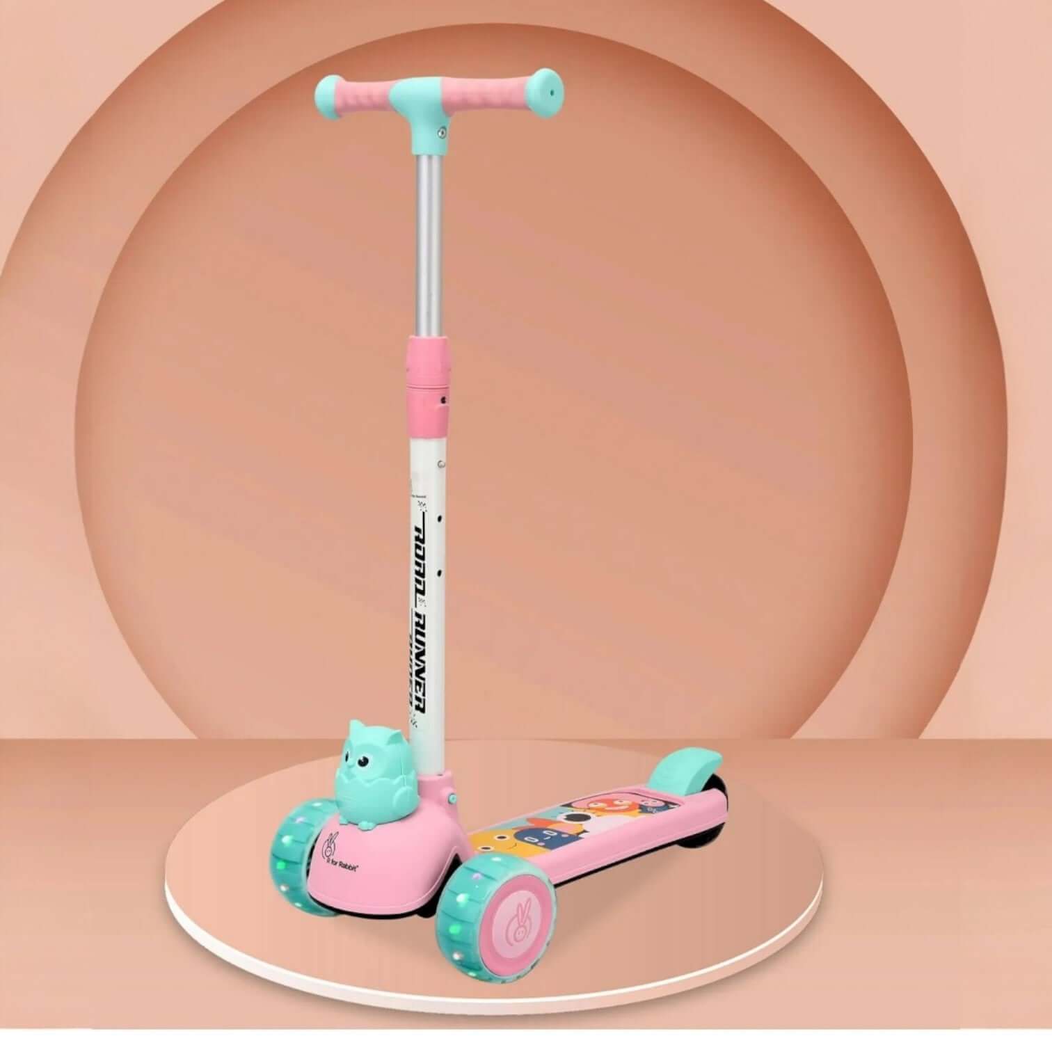 Children's scooter with pink and teal design on a peach-colored background