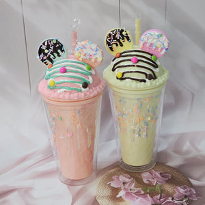 Two adorable Usmile Toys novelty tumblers, one pink and one lime green, each topped with a playful 'ice cream' lid decorated with colorful sprinkles and chocolate drizzle, complete with a straw and an Oreo-shaped charm. Perfect for kids' drinks and adding fun to everyday hydration." www.usmile.toys