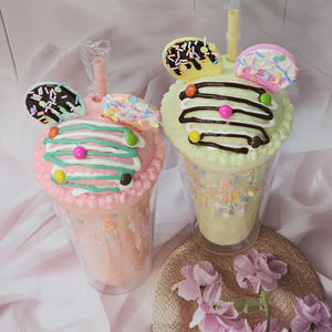 Two adorable Usmile Toys novelty tumblers, one pink and one lime green, each topped with a playful 'ice cream' lid decorated with colorful sprinkles and chocolate drizzle, complete with a straw and an Oreo-shaped charm. Perfect for kids' drinks and adding fun to everyday hydration." www.usmile.toys
