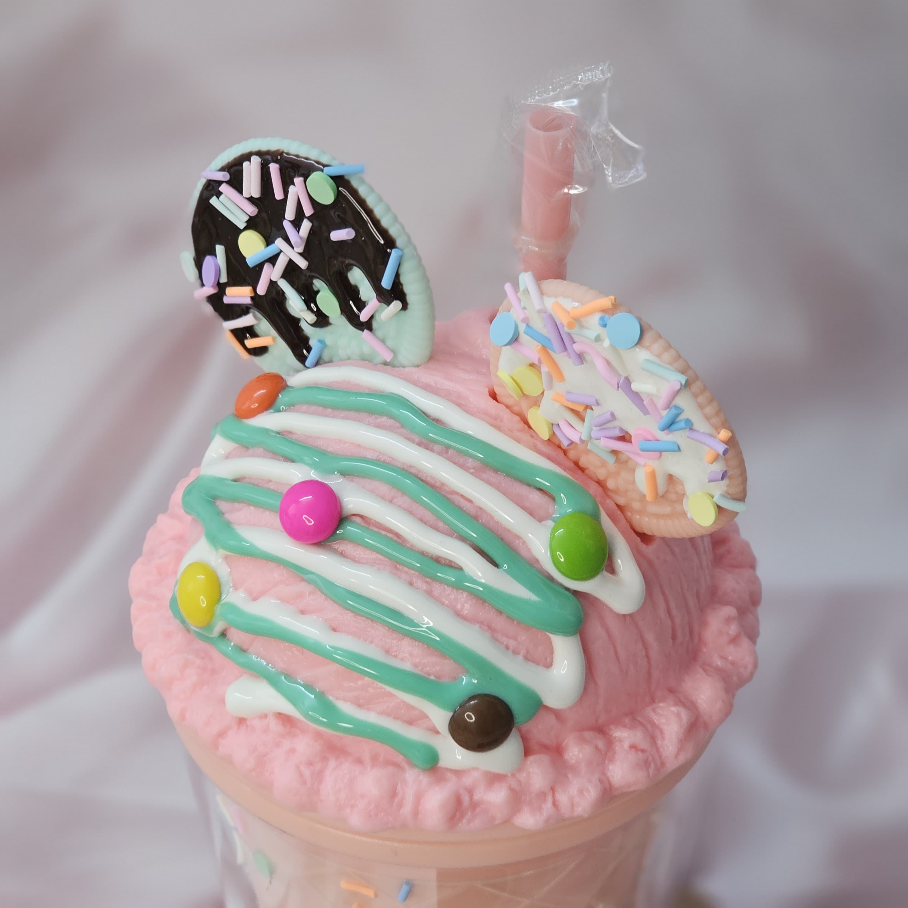 Fun Usmile Toys 'Oreo ice cream' themed tumblers for kids, featuring a pink tumbler with mint green 'frosting' and sprinkles, and a lime green tumbler with chocolate drizzle. These unique sipper cups are ideal for parties and making drinks exciting." www.usmile.toys