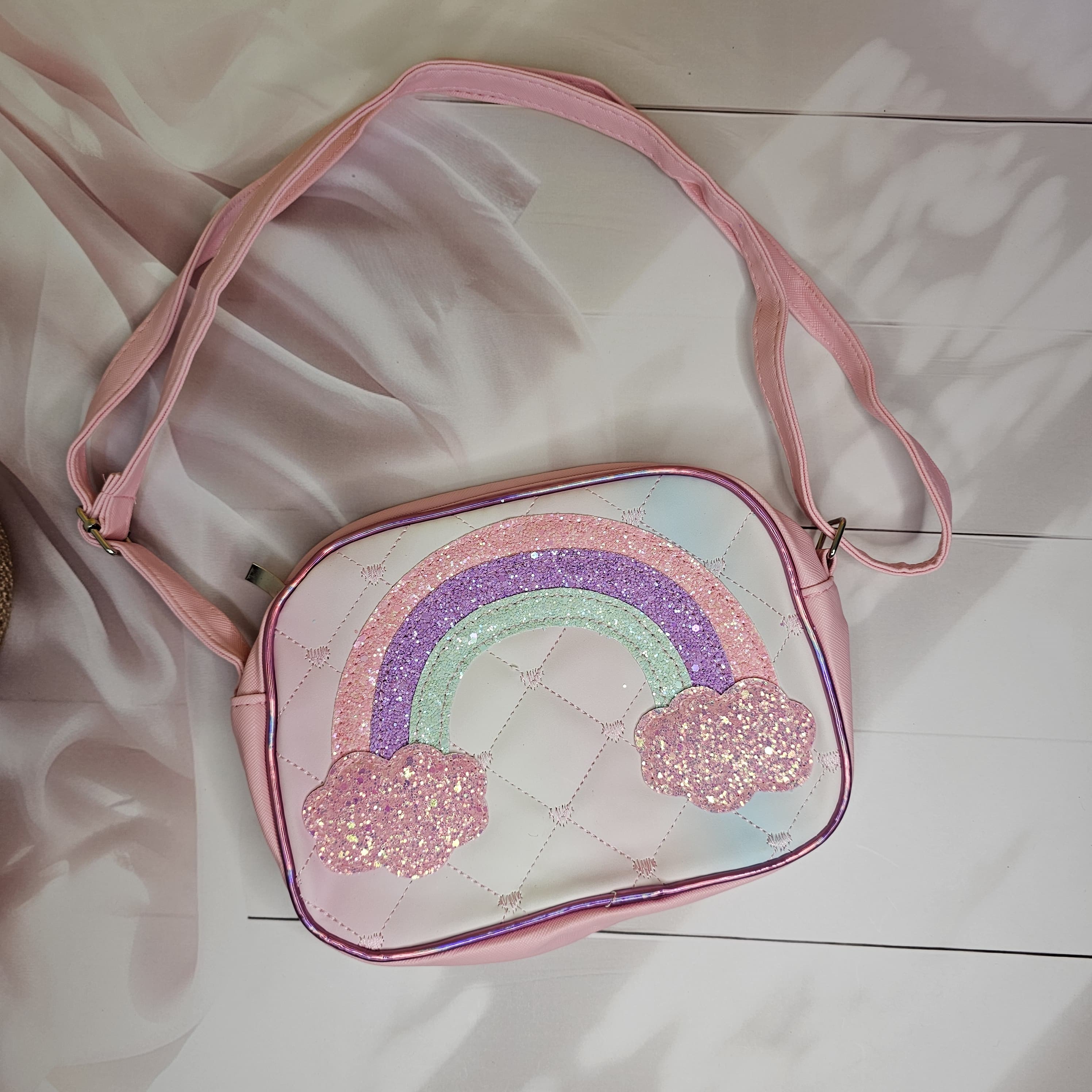 Stylish rainbow glitter sling bag with a single chain strap and shaded rainbow design, a trendy accessory for girls in www.usmile.toys
