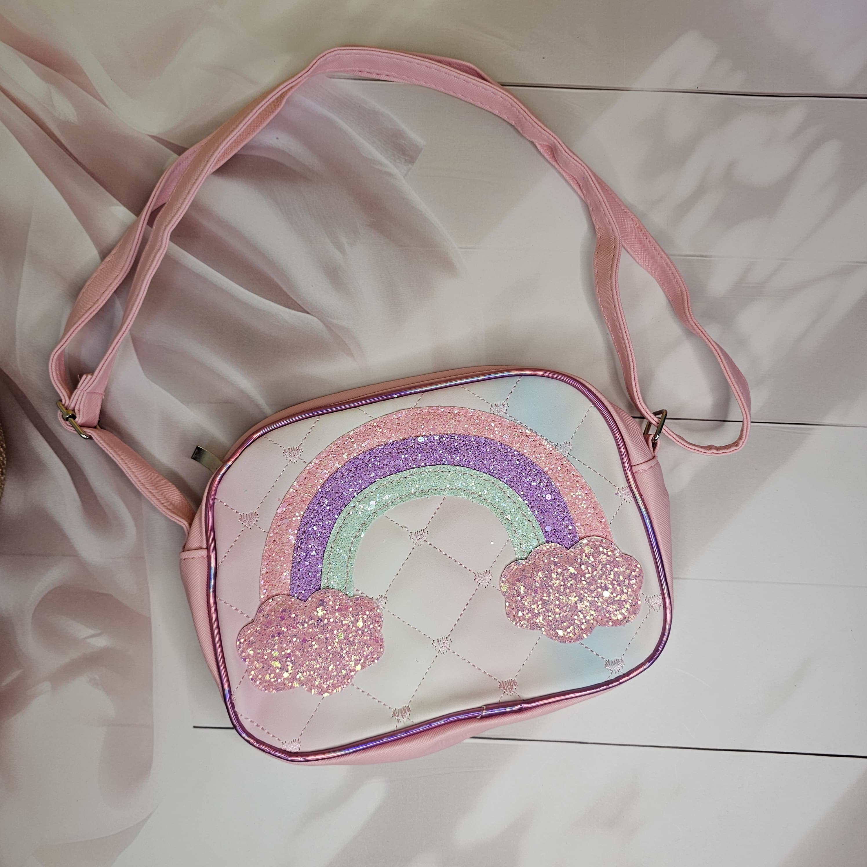 Stylish rainbow glitter sling bag with a single chain strap and shaded rainbow design, a trendy accessory for girls in www.usmile.toys
